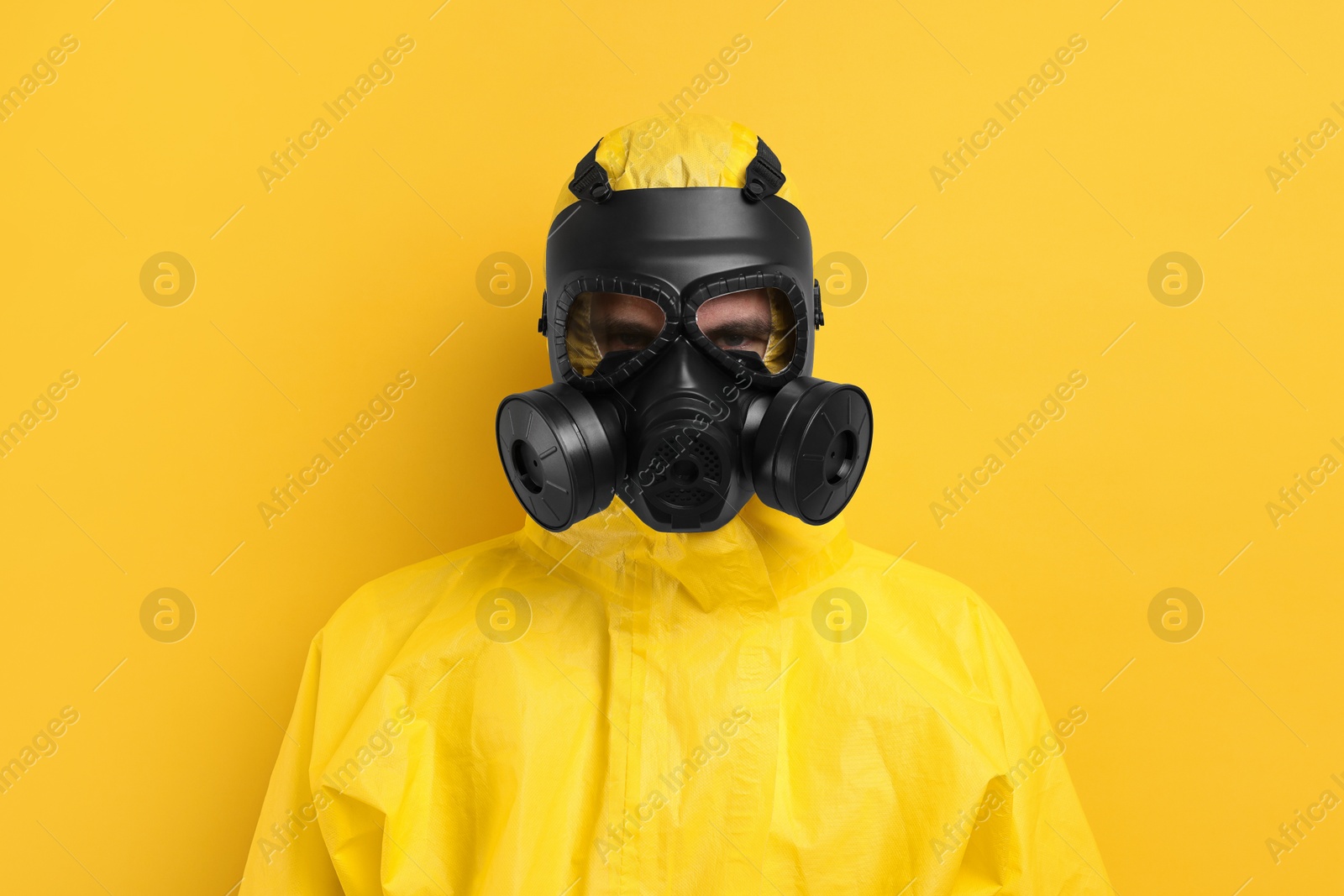 Photo of Worker in gas mask on yellow background