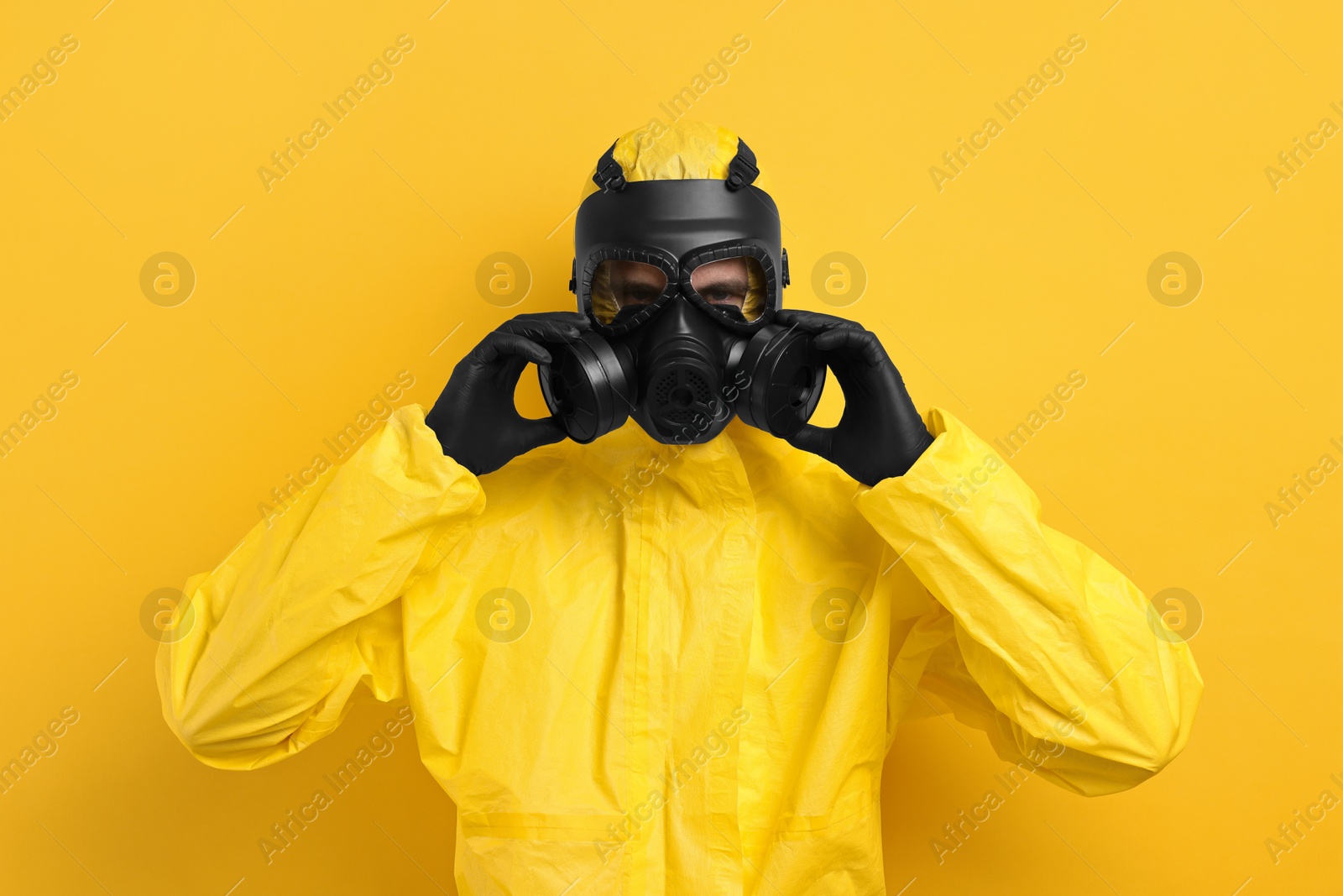 Photo of Worker in gas mask on yellow background
