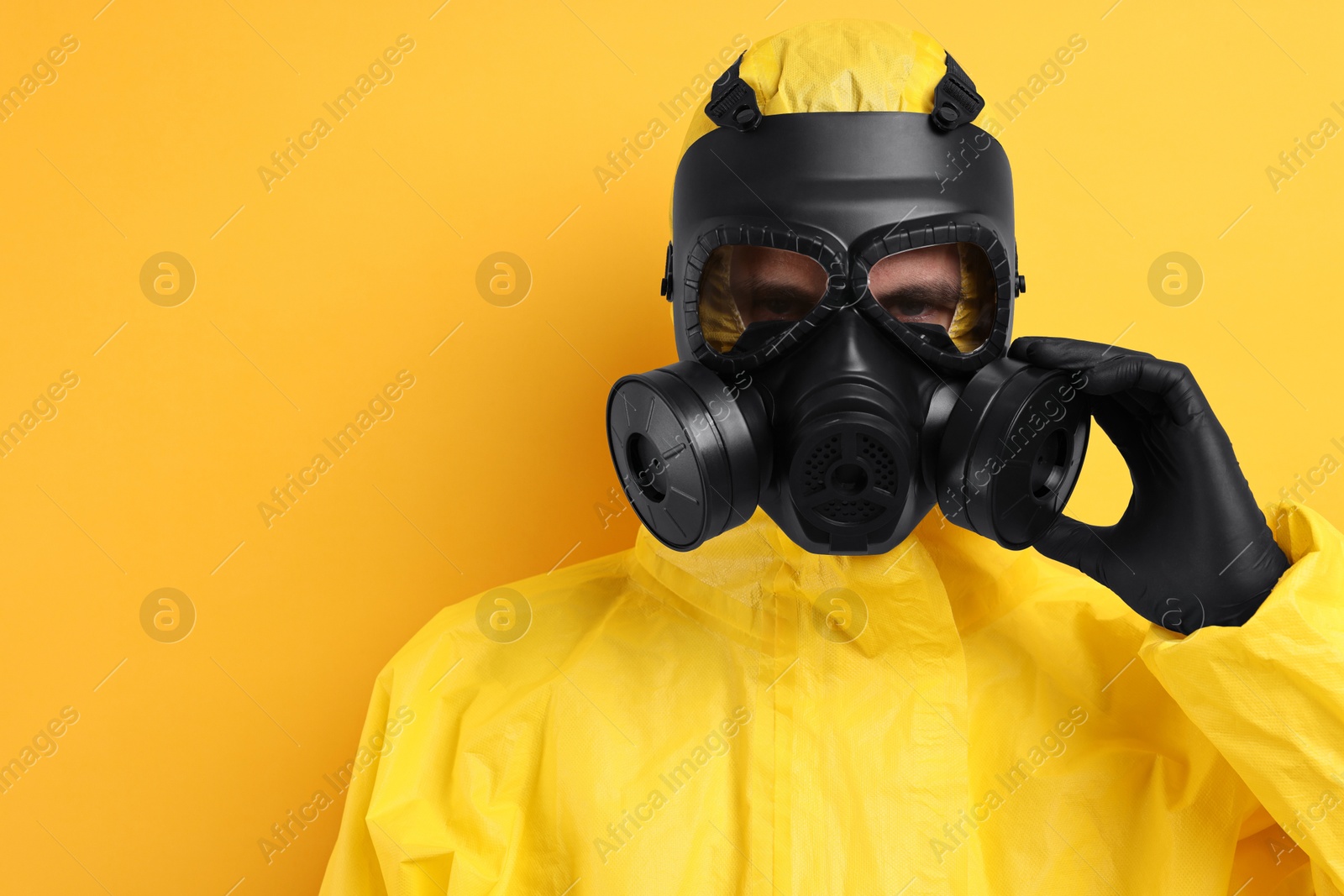 Photo of Worker in gas mask on yellow background. Space for text