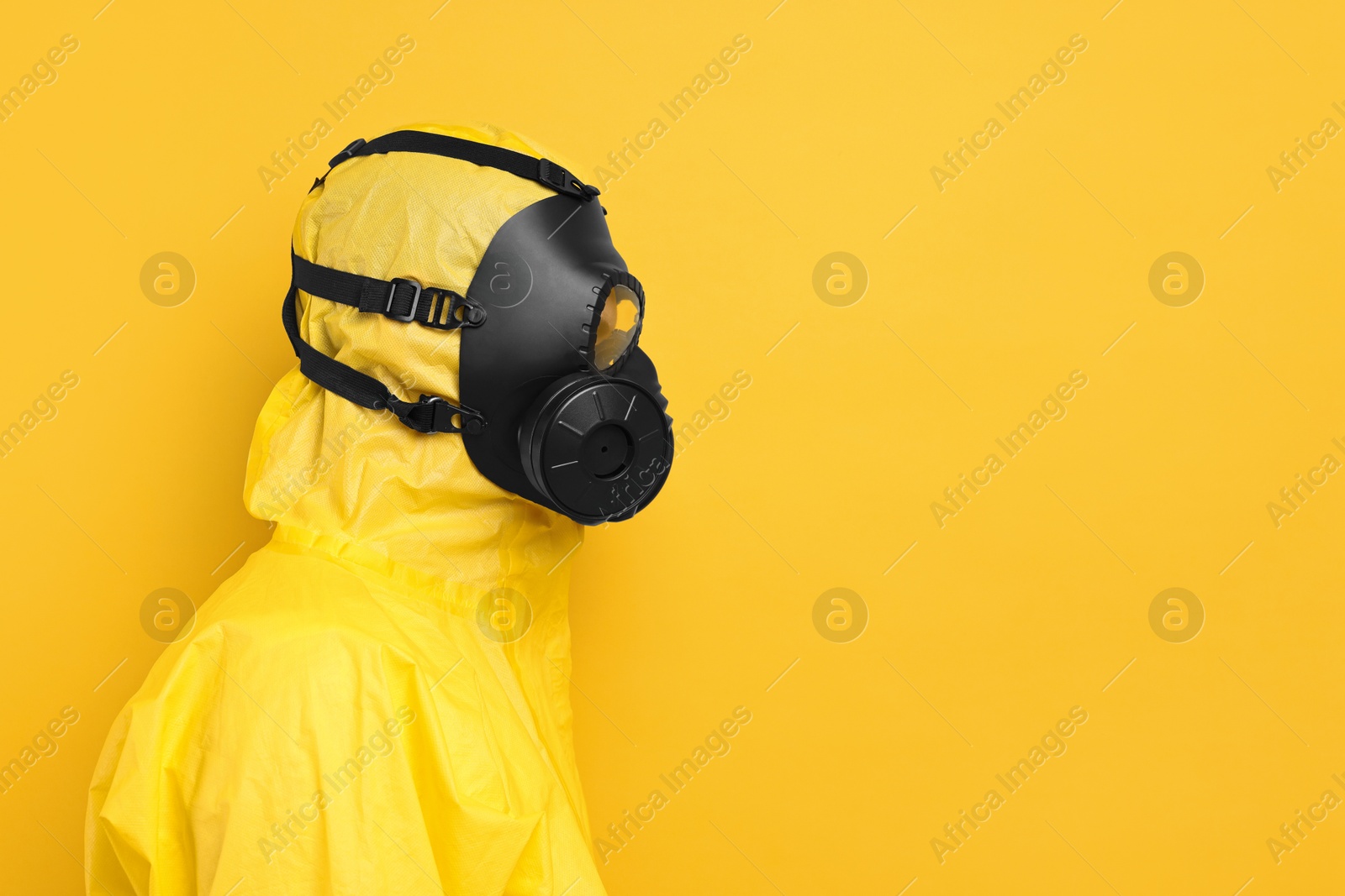 Photo of Worker in gas mask on yellow background. Space for text