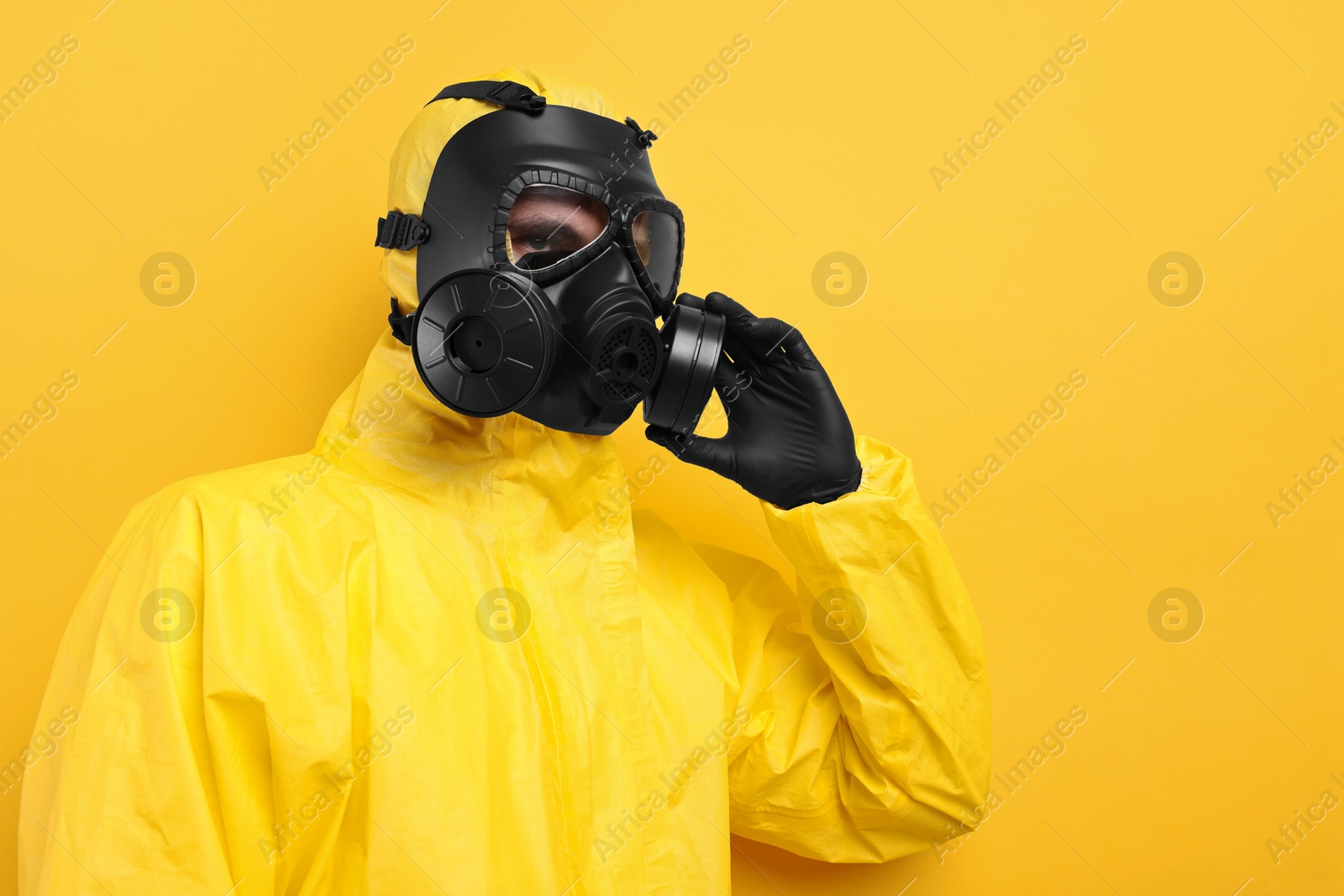 Photo of Worker in gas mask on yellow background. Space for text