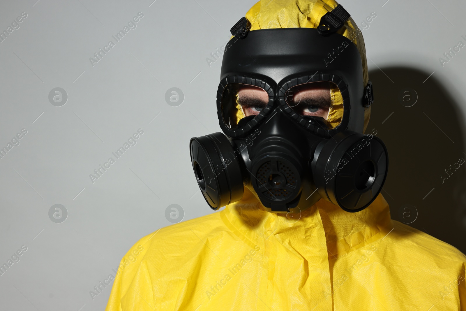 Photo of Worker in gas mask on grey background. Space for text