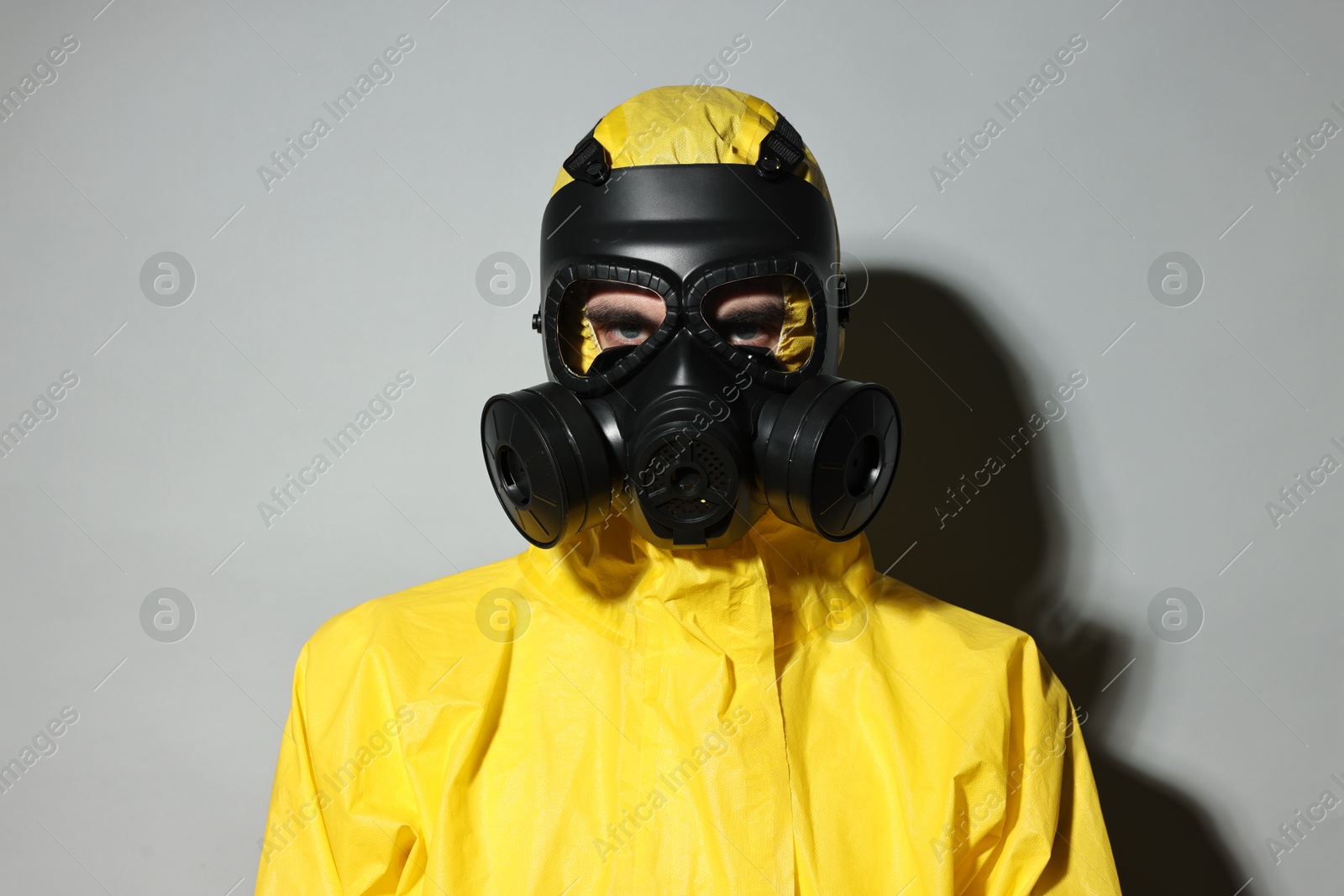Photo of Worker in gas mask on grey background