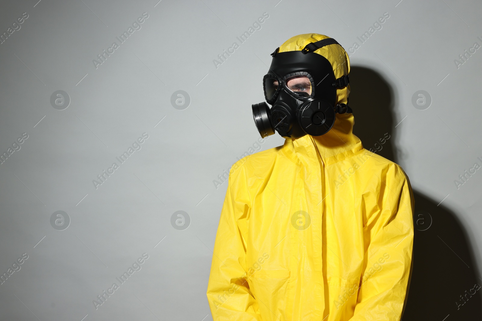 Photo of Worker in gas mask on grey background. Space for text
