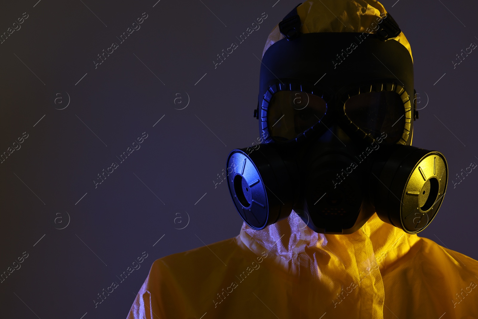 Photo of Worker in gas mask on dark background. Space for text