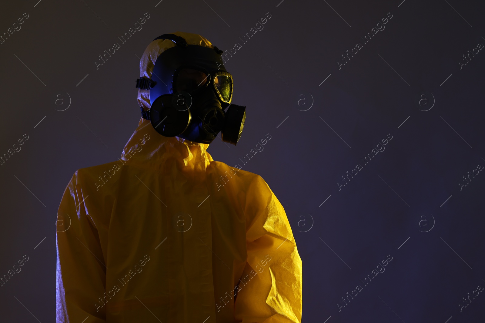 Photo of Worker in gas mask on dark background, low angle view. Space for text