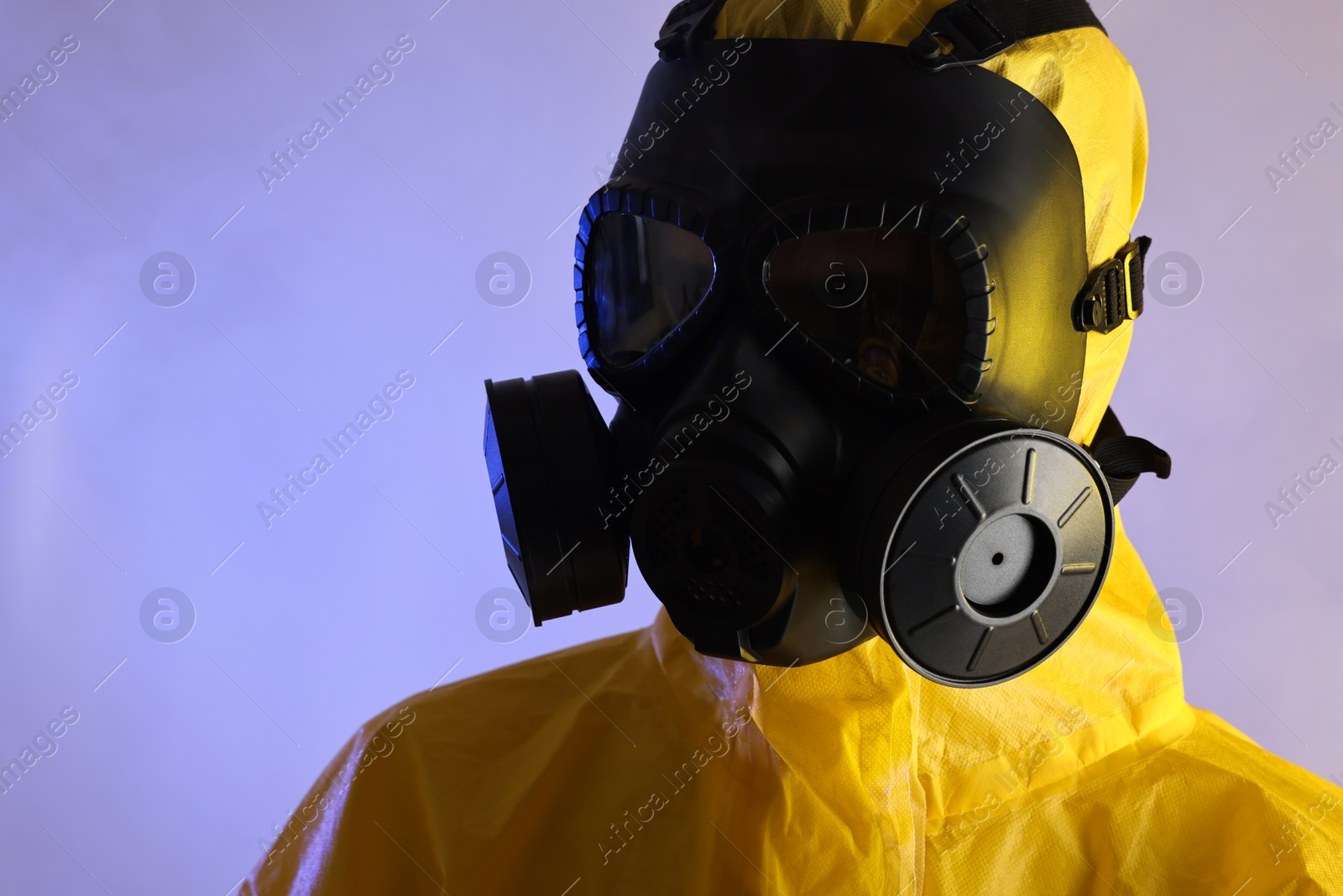Photo of Worker in gas mask on violet background, closeup