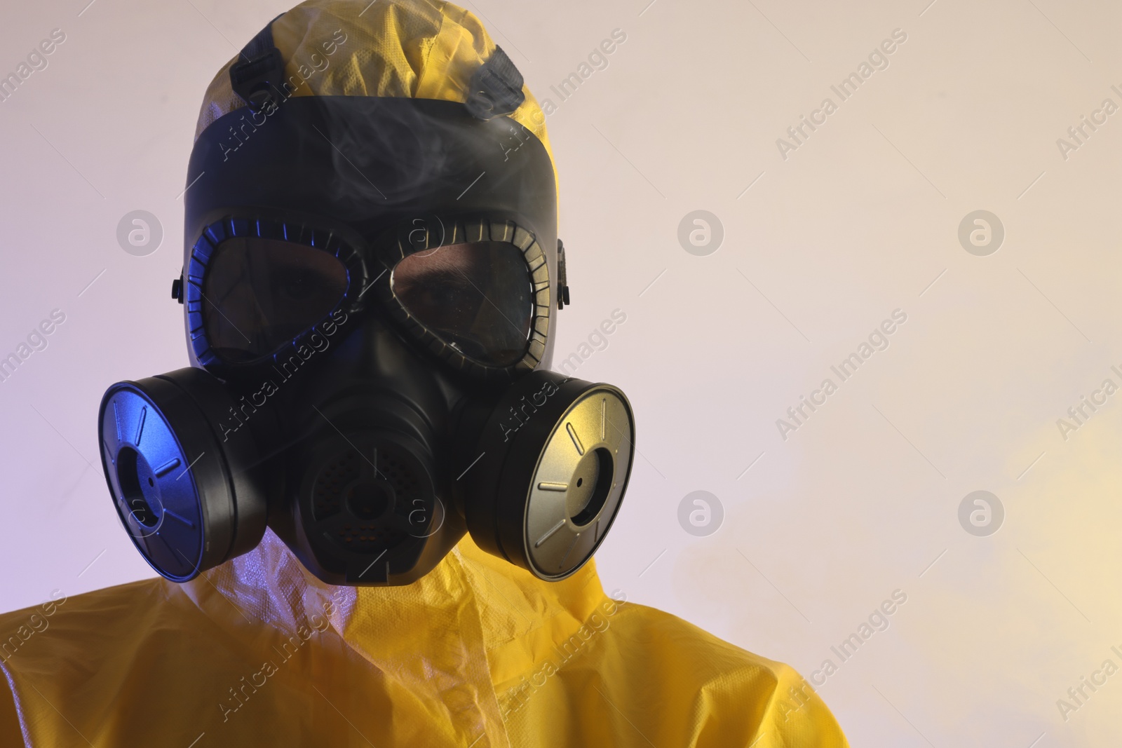 Photo of Worker in gas mask on light background, closeup. Space for text