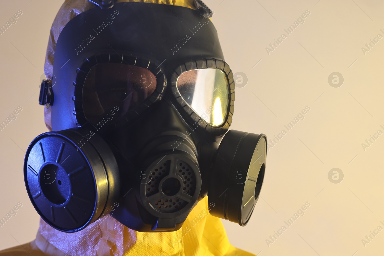 Photo of Worker in gas mask on light background, closeup