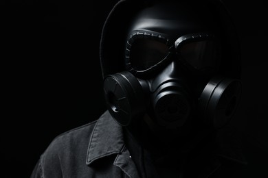 Photo of Man in gas mask on black background, closeup