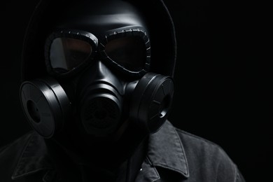 Man in gas mask on black background, closeup
