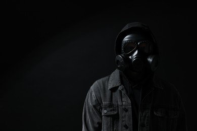 Man in gas mask on black background. Space for text