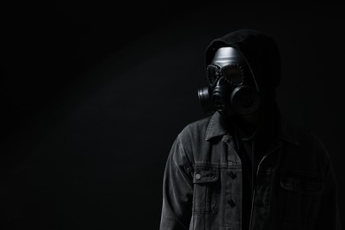 Man in gas mask on black background. Space for text
