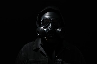 Man in gas mask on black background