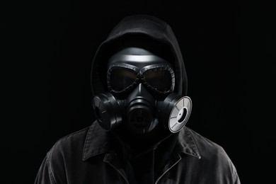 Man in gas mask on black background