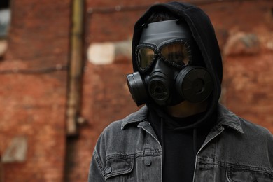 Man in gas mask outdoors. Space for text