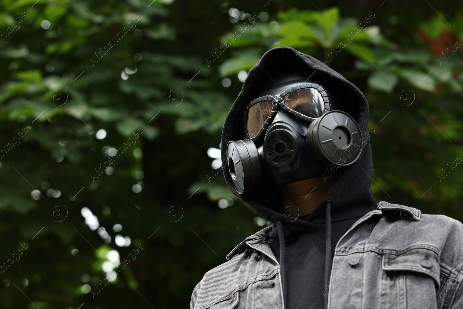 Photo of Man in gas mask outdoors, low angle view. Space for text