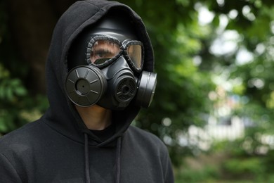 Photo of Man in gas mask outdoors. Space for text