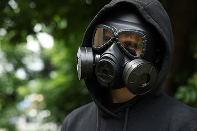 Man in gas mask outdoors. Space for text