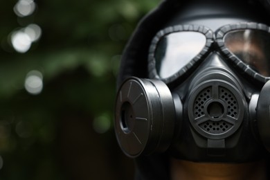 Photo of Man in gas mask outdoors, closeup. Space for text