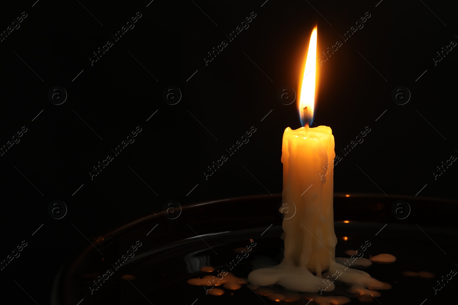 Photo of One burning church candle on black background, space for text