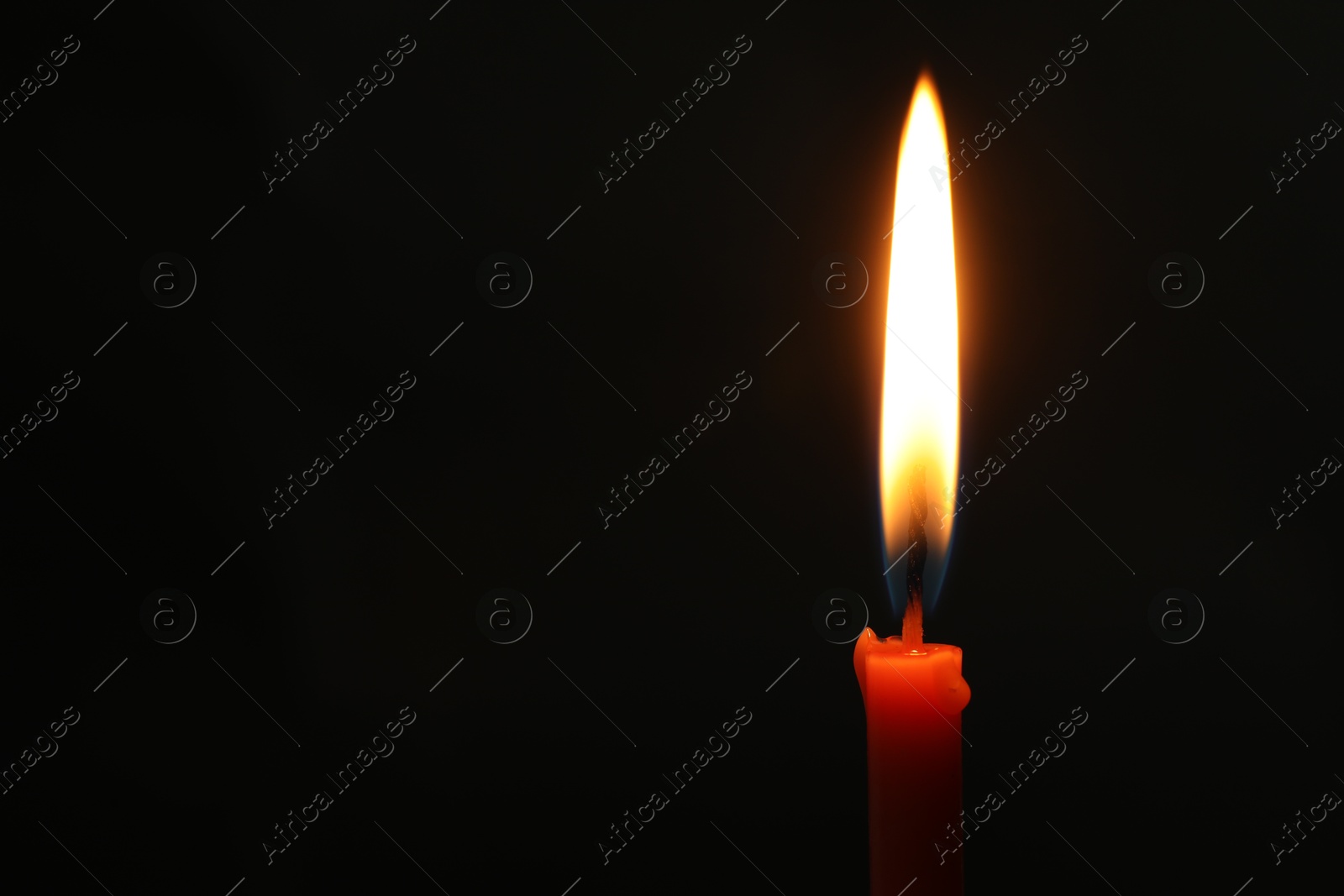 Photo of One burning church candle on black background, space for text