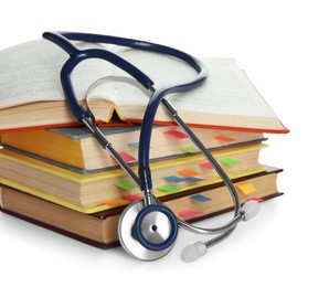 Stethoscope on stack of books against white background