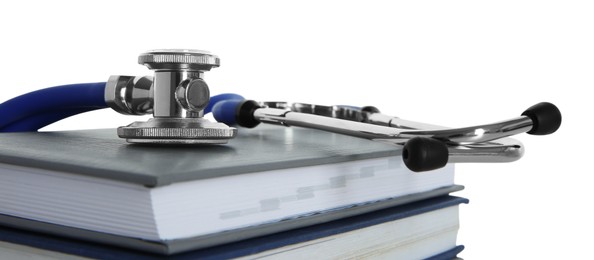 Stethoscope on stack of books against white background