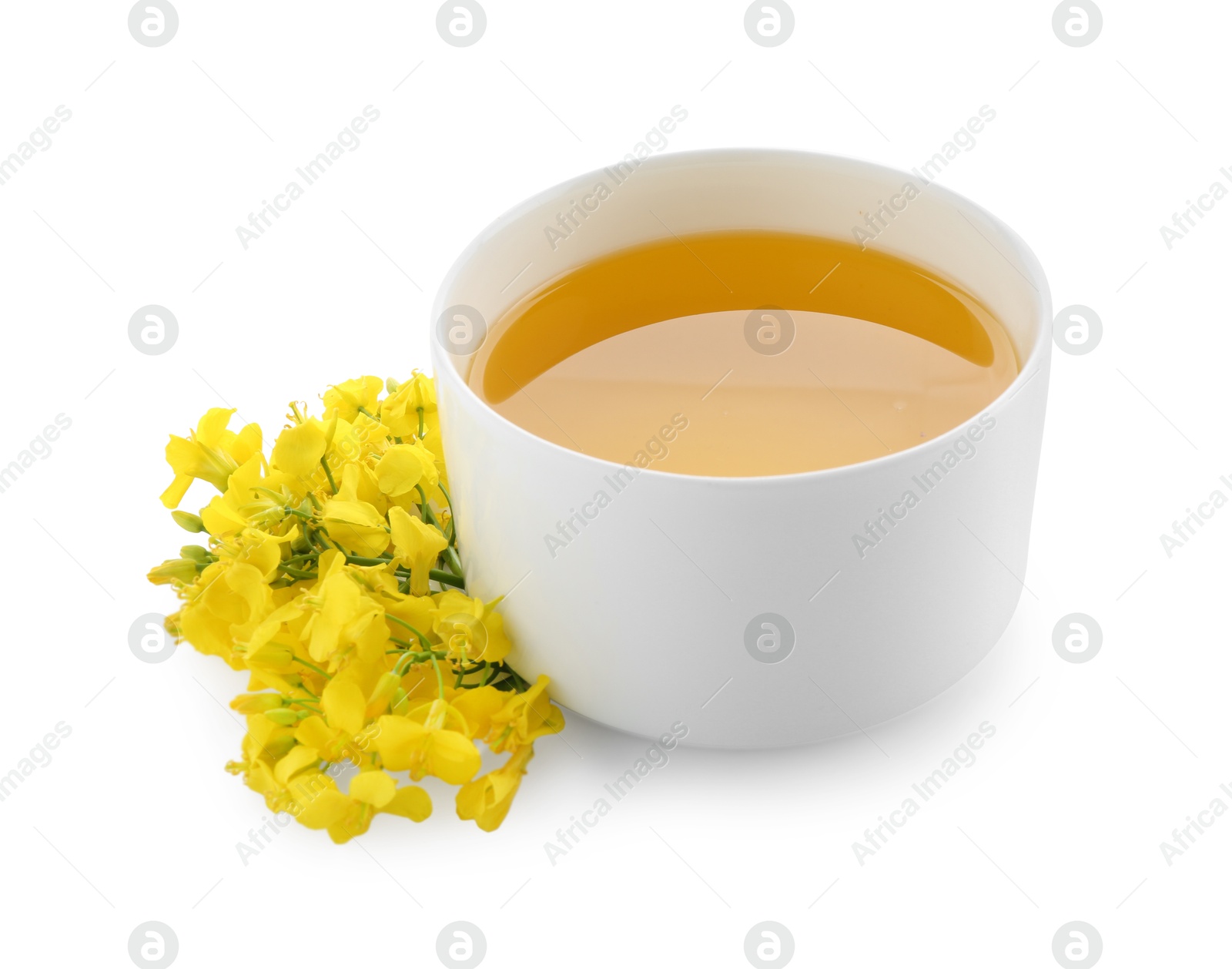 Photo of Rapeseed oil in bowl and beautiful yellow flowers isolated on white
