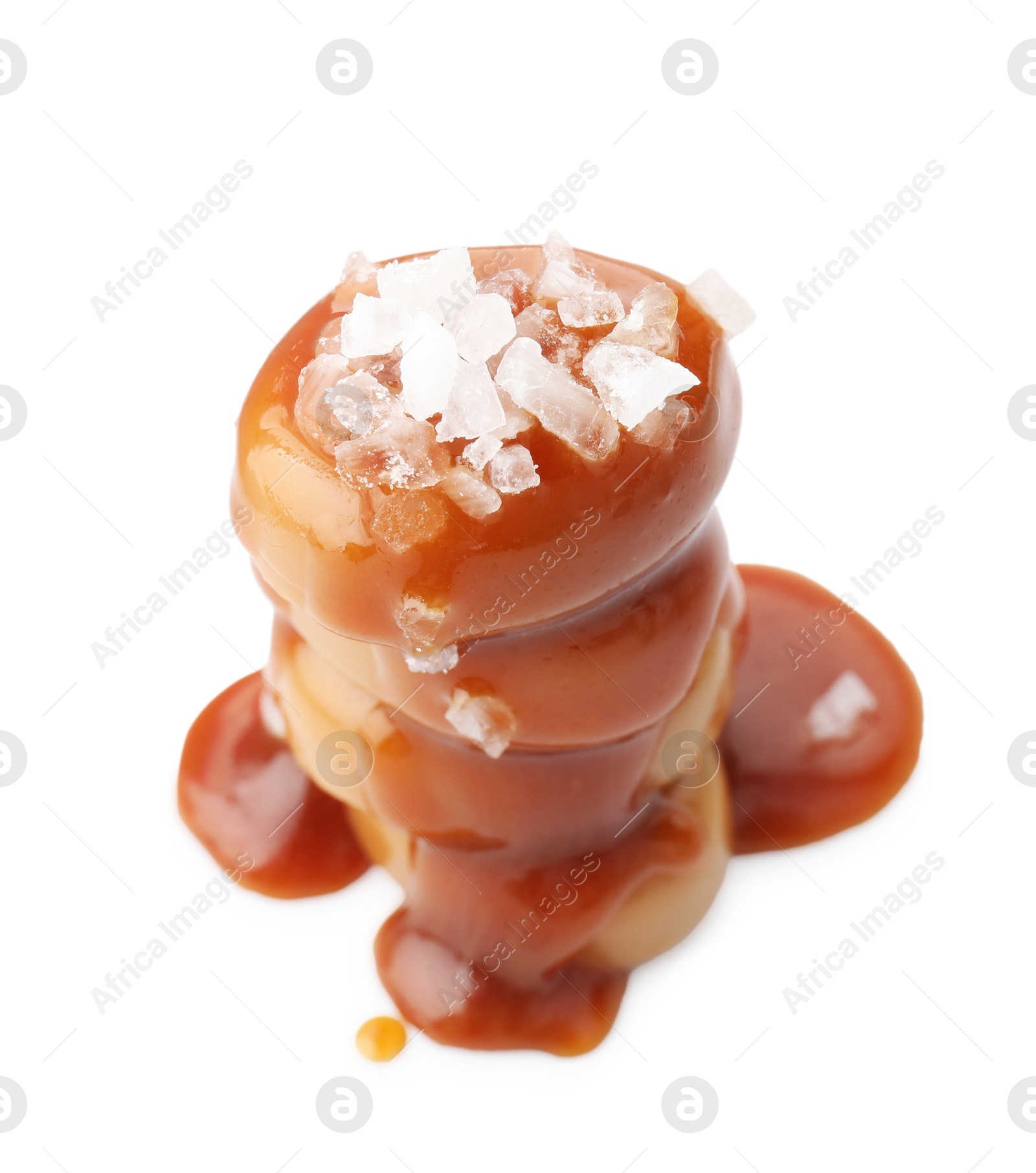 Photo of Yummy candies with caramel sauce and sea salt isolated on white