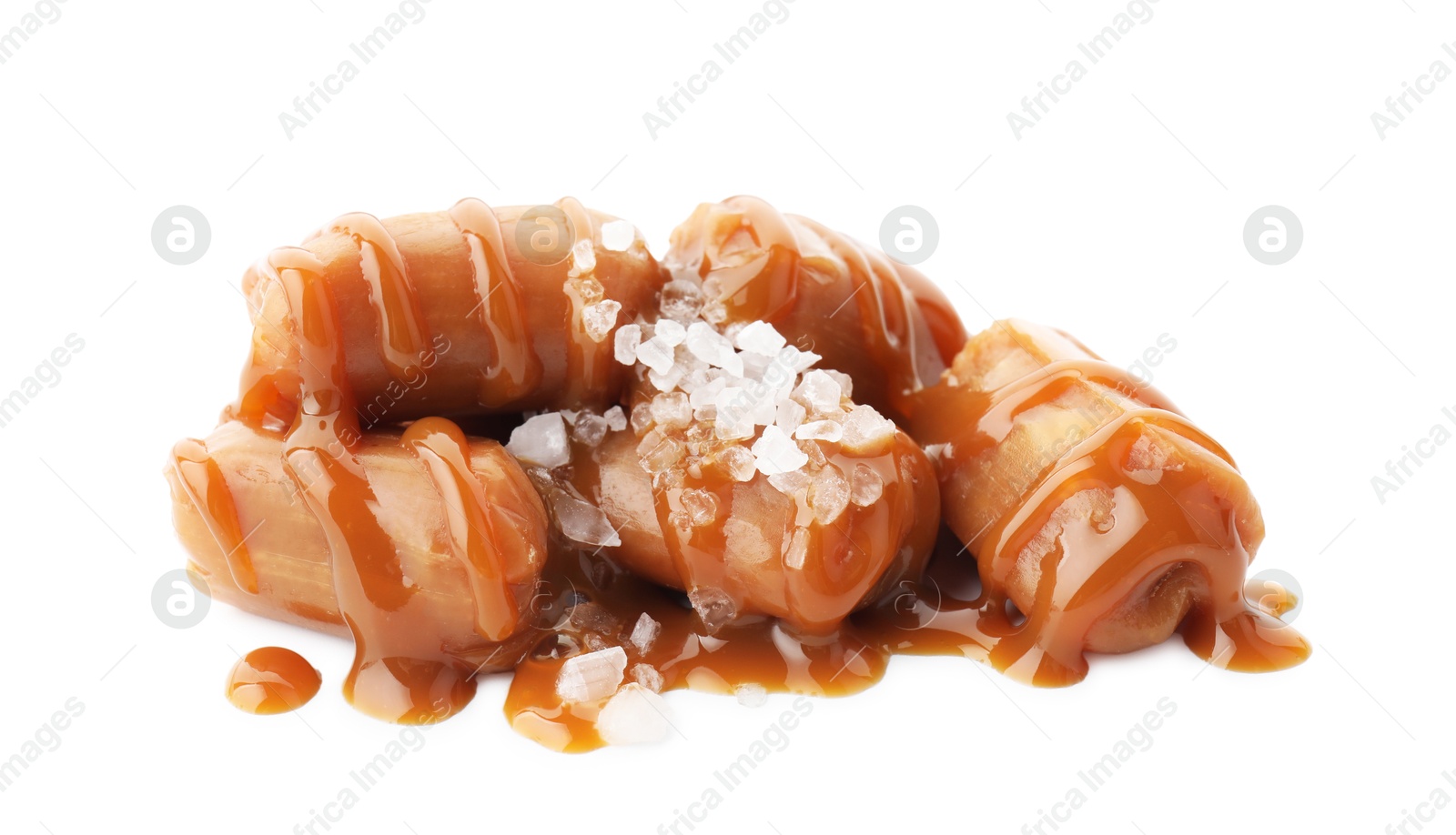 Photo of Yummy candies with caramel sauce and sea salt isolated on white