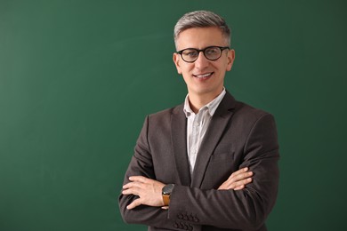 Teacher in glasses near chalkboard, space for text