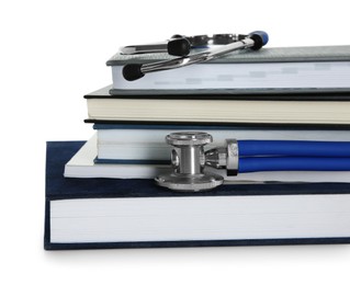 Photo of Stethoscope and stack of books isolated on white