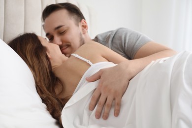 Lovely couple enjoying time together in bed at morning