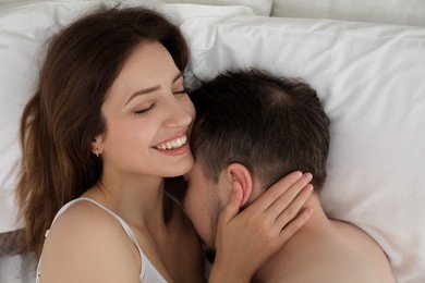 Lovely couple enjoying time together in bed at morning, top view
