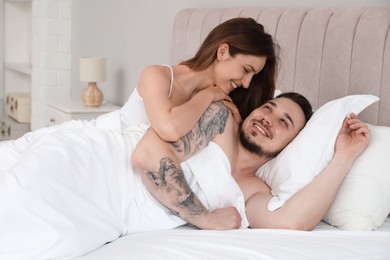 Lovely couple enjoying time together in bed at morning