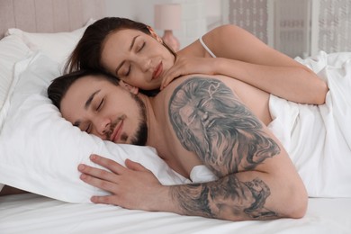 Lovely couple sleeping together in bed at home