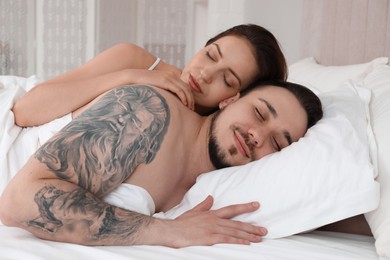 Lovely couple sleeping together in bed at home