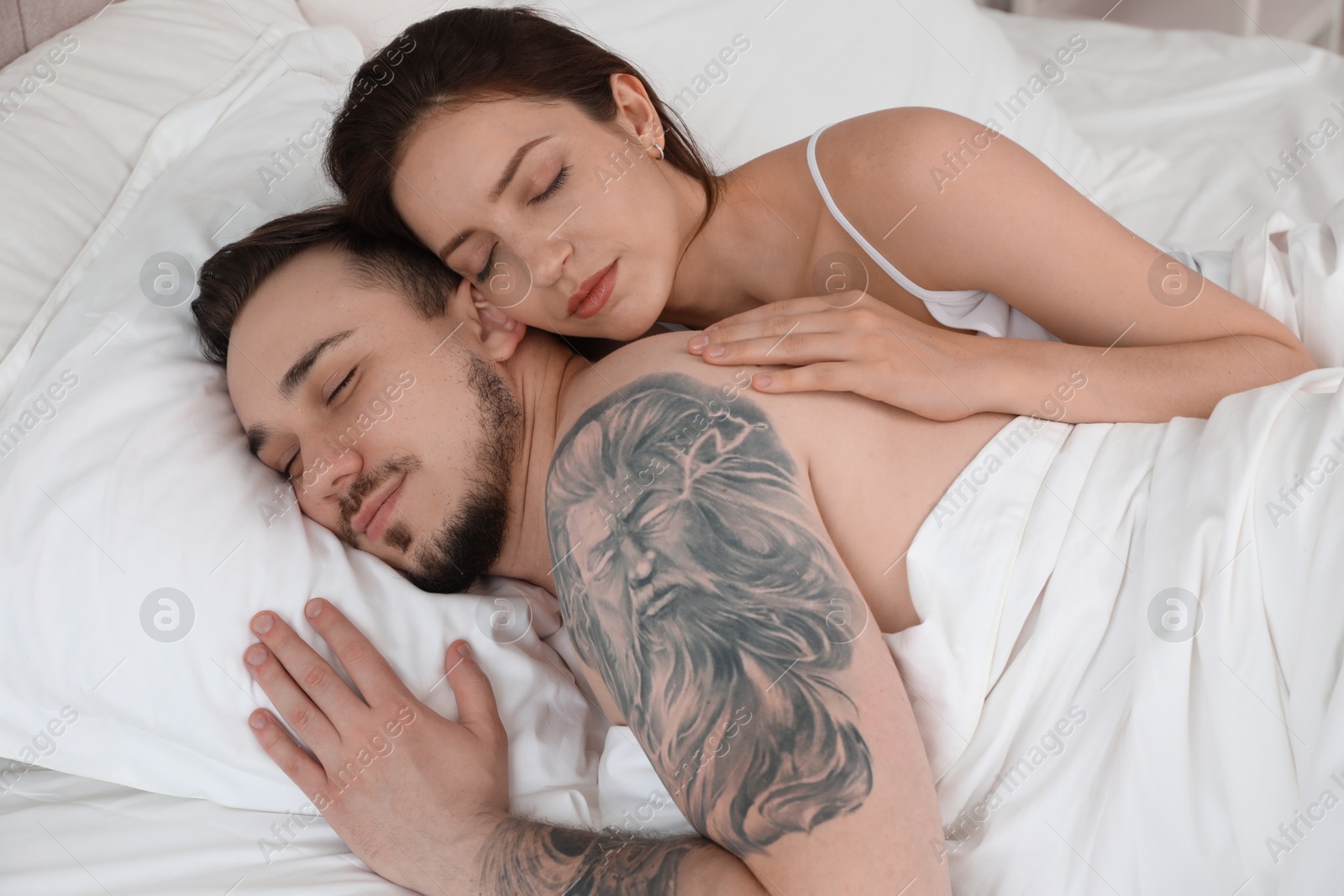 Photo of Lovely couple sleeping together in bed at home