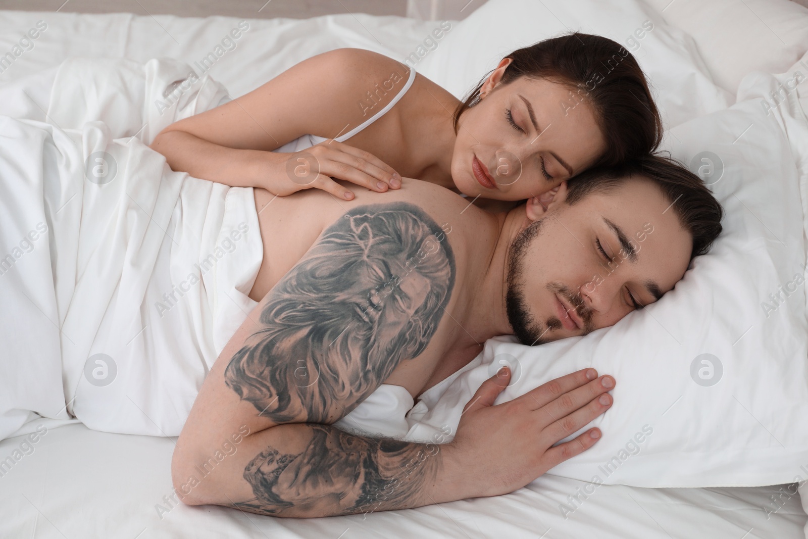 Photo of Lovely couple sleeping together in bed at home