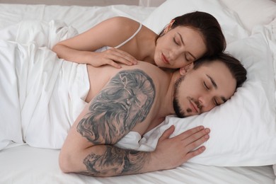 Lovely couple sleeping together in bed at home