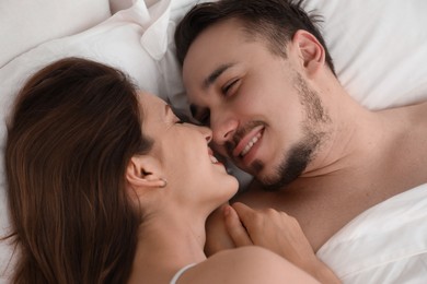 Photo of Lovely couple enjoying time together in bed at morning, closeup