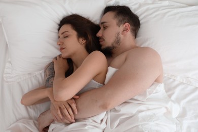 Photo of Lovely couple sleeping together in bed at home, top view