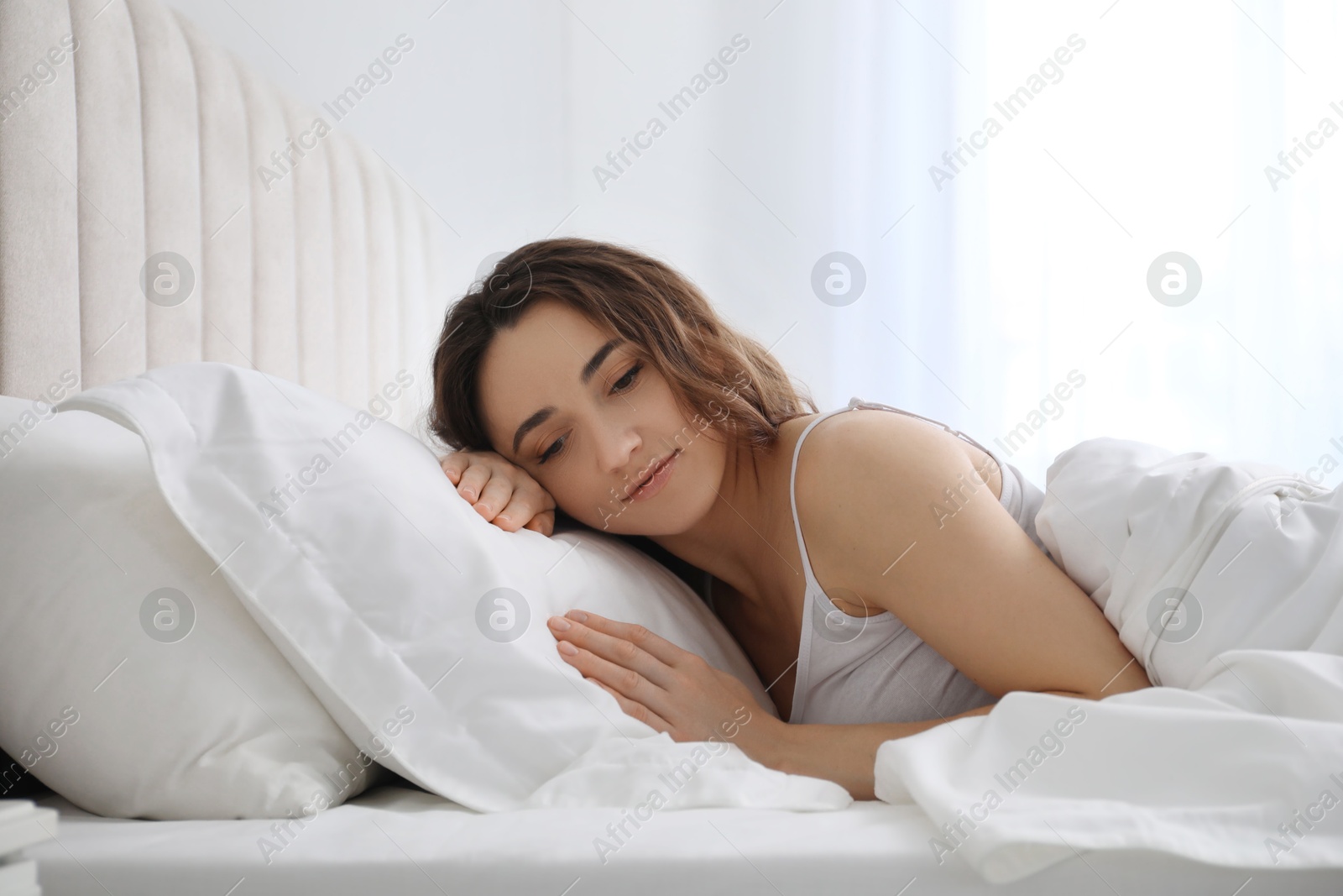 Photo of Bedtime. Beautiful woman lying in bed at morning