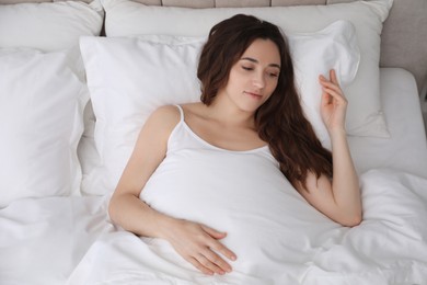 Photo of Beautiful woman lying in bed at morning, top view