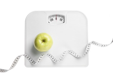 Photo of Scale, measuring tape and fresh apple isolated on white, top view