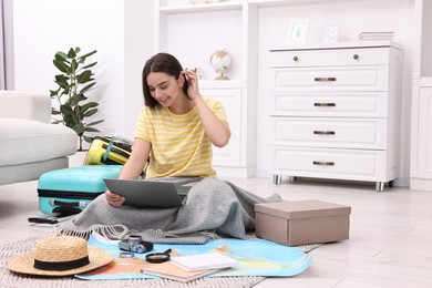 Photo of Travel blogger using laptop for planning trip at home