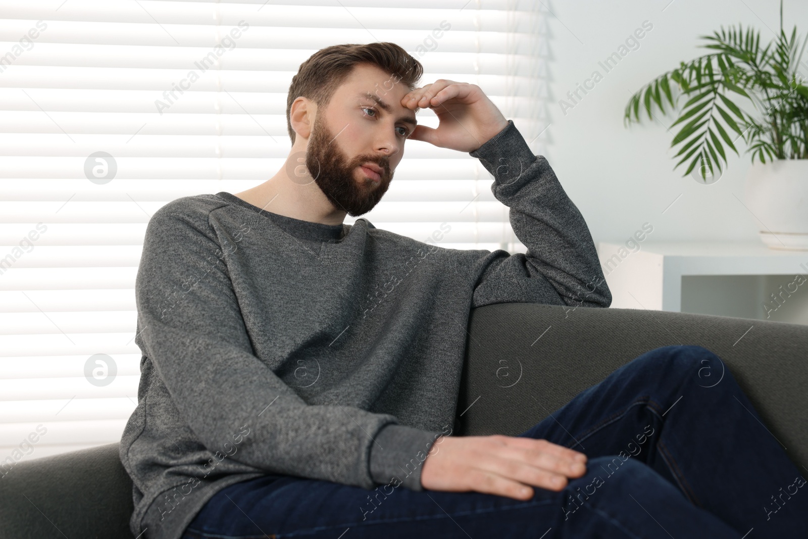 Photo of Loneliness concept. Sad man sitting on sofa at home