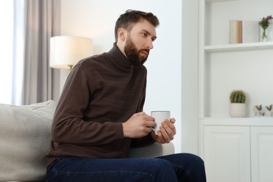 Photo of Loneliness concept. Sad man sitting on sofa at home