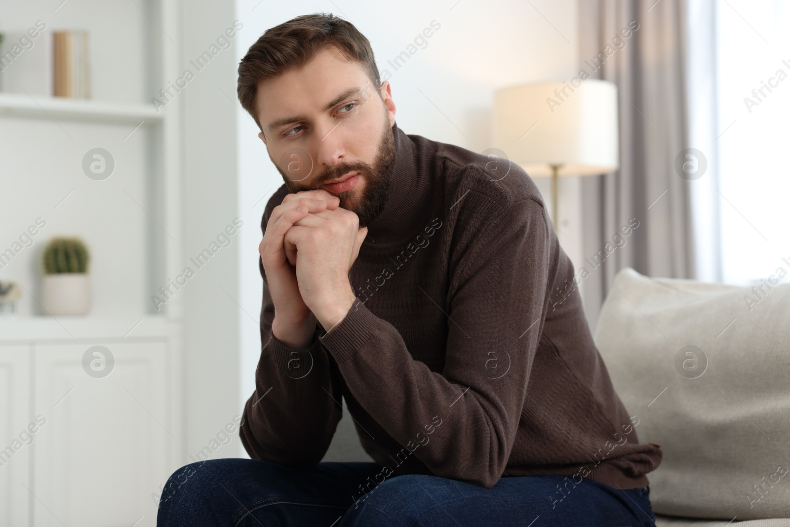 Photo of Loneliness concept. Sad man sitting on sofa at home